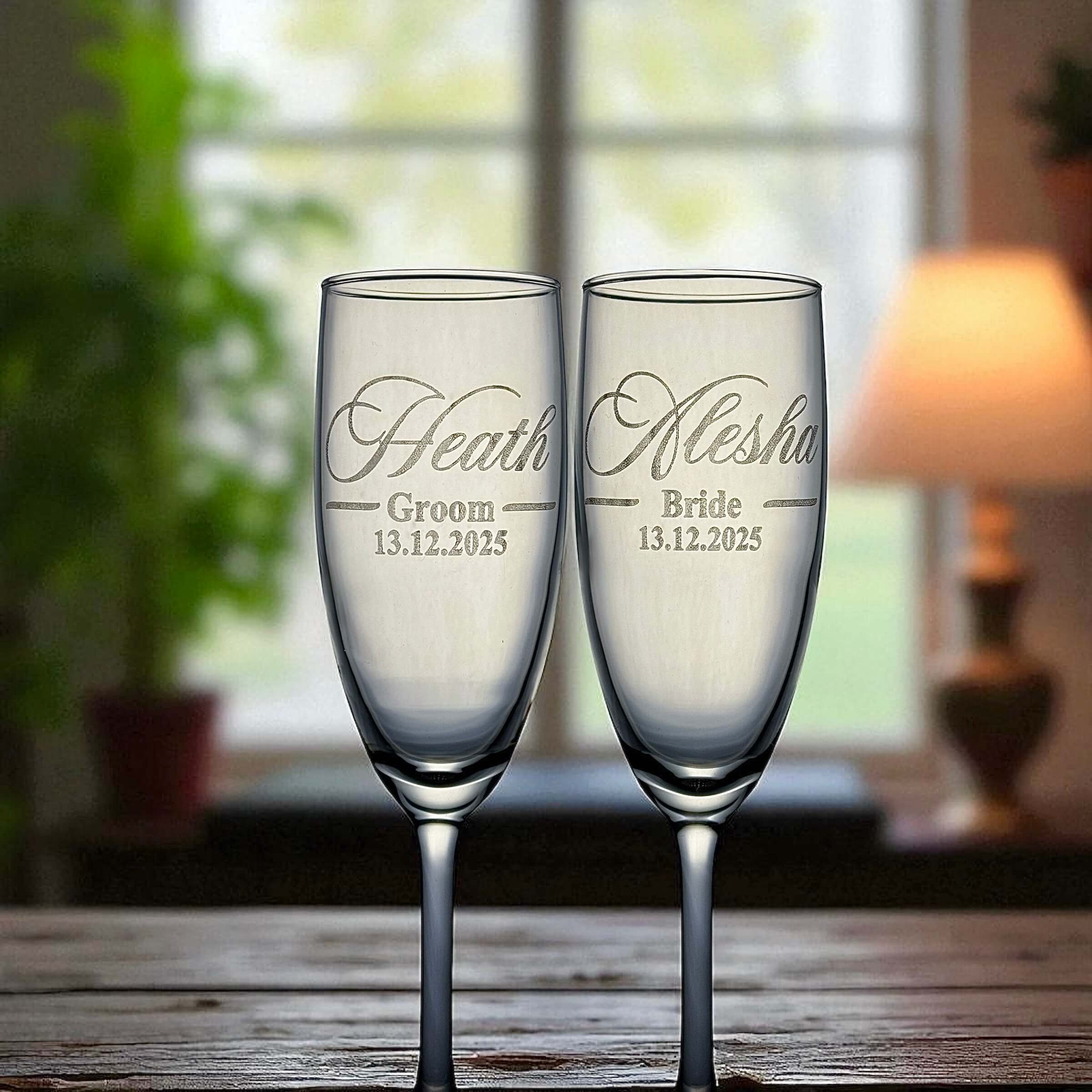 Bride and groom personalised champagne flutes displayed at a wedding table.