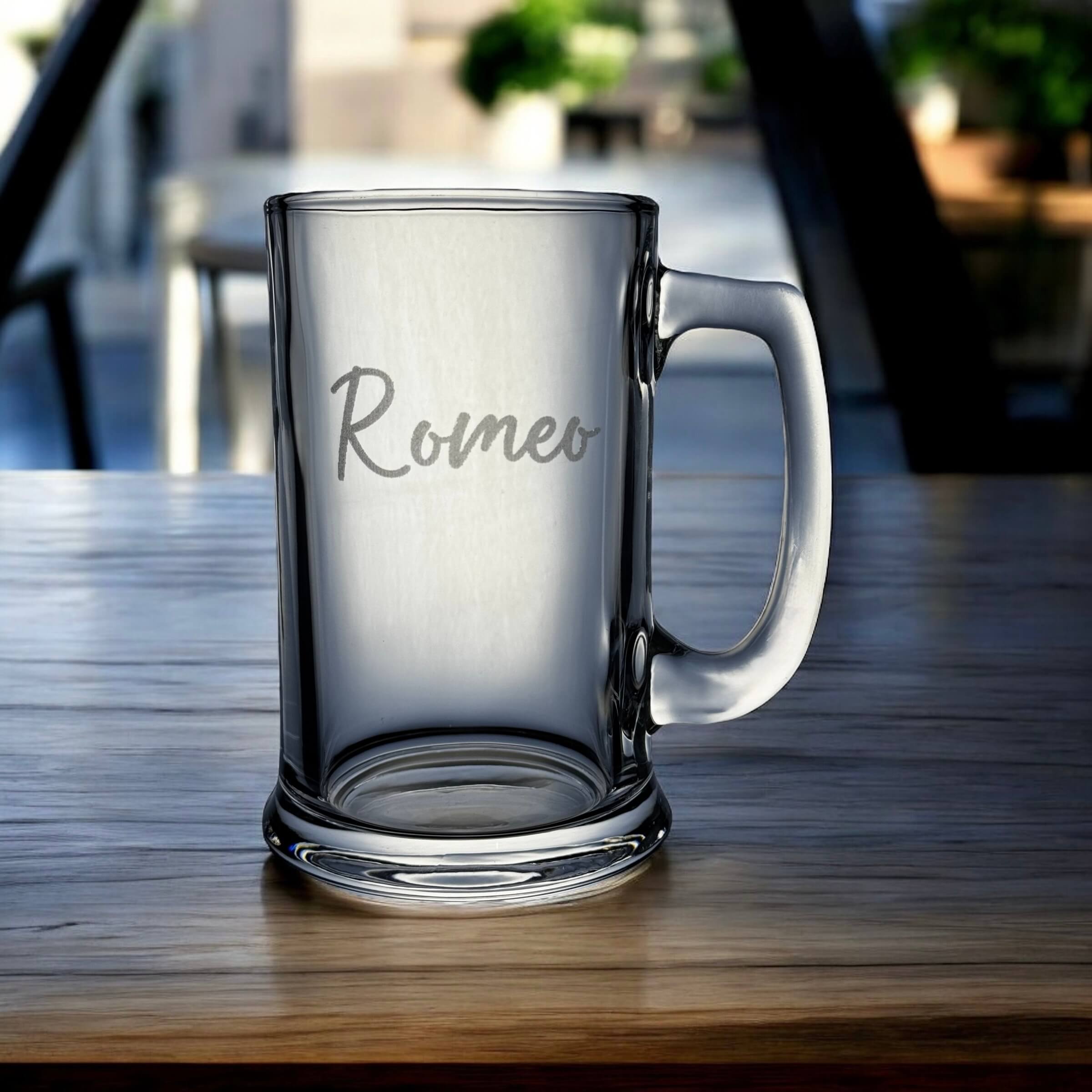 Clear glass mug with 'Romeo' engraving on a wooden table