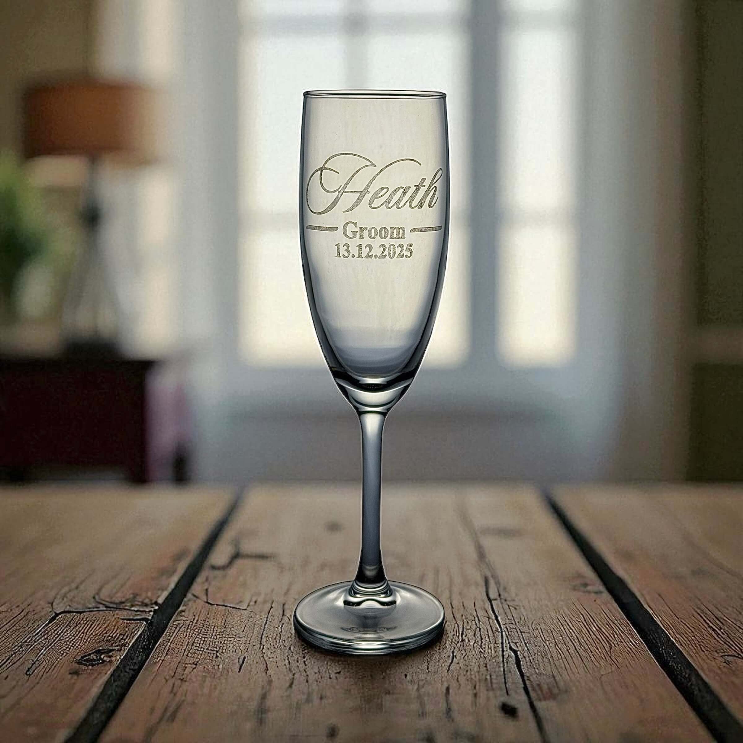 Elegant crystal champagne flutes engraved for bride and groom with wedding date detail.