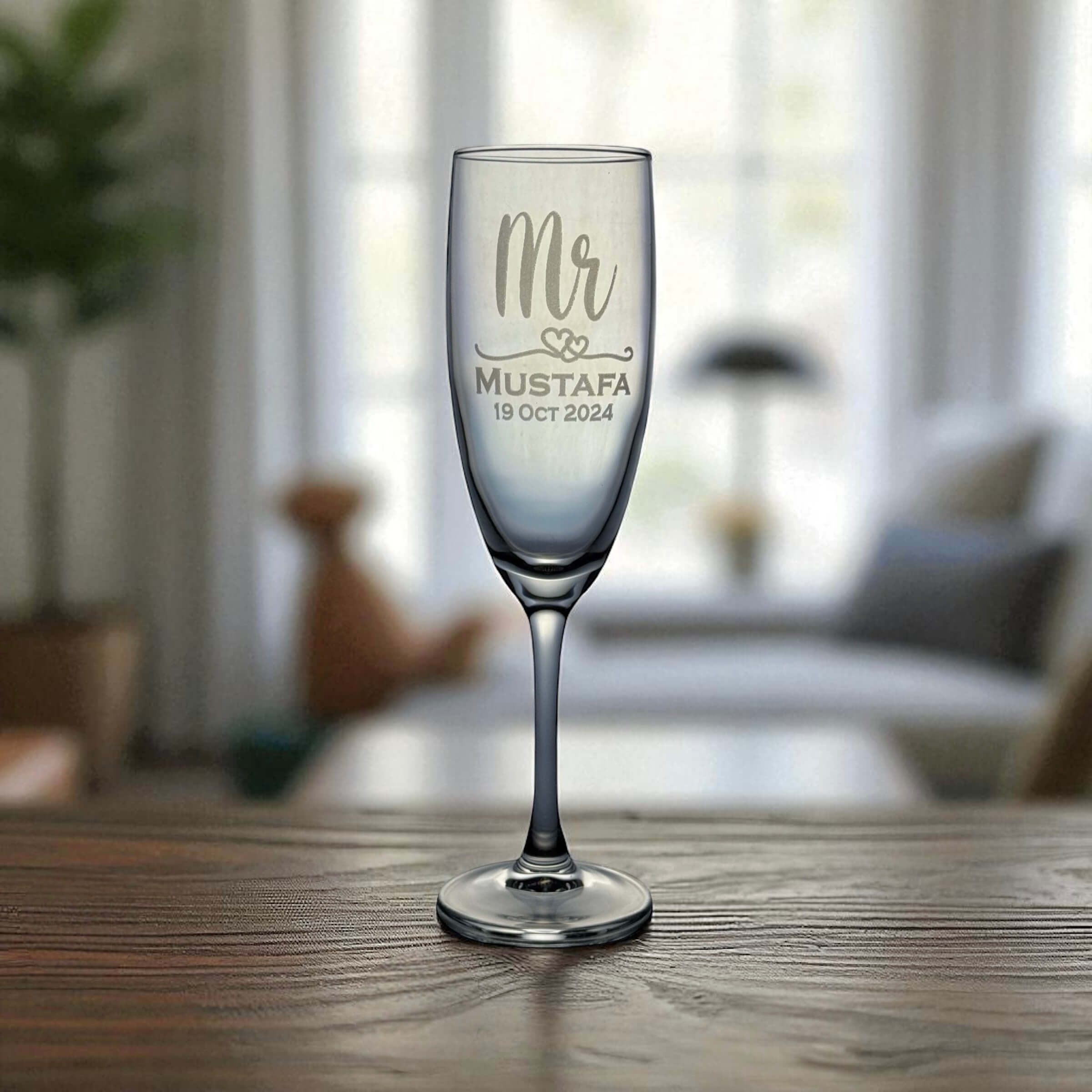 Personalised champagne flute with engraved name and date on a wooden table