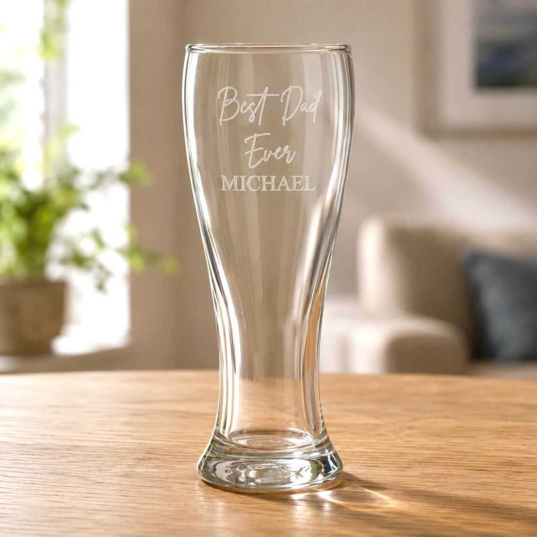 Clear pilsner beer glass engraved with Best Dad Ever and name Michael on a wooden table, a personalised Father's Day gift