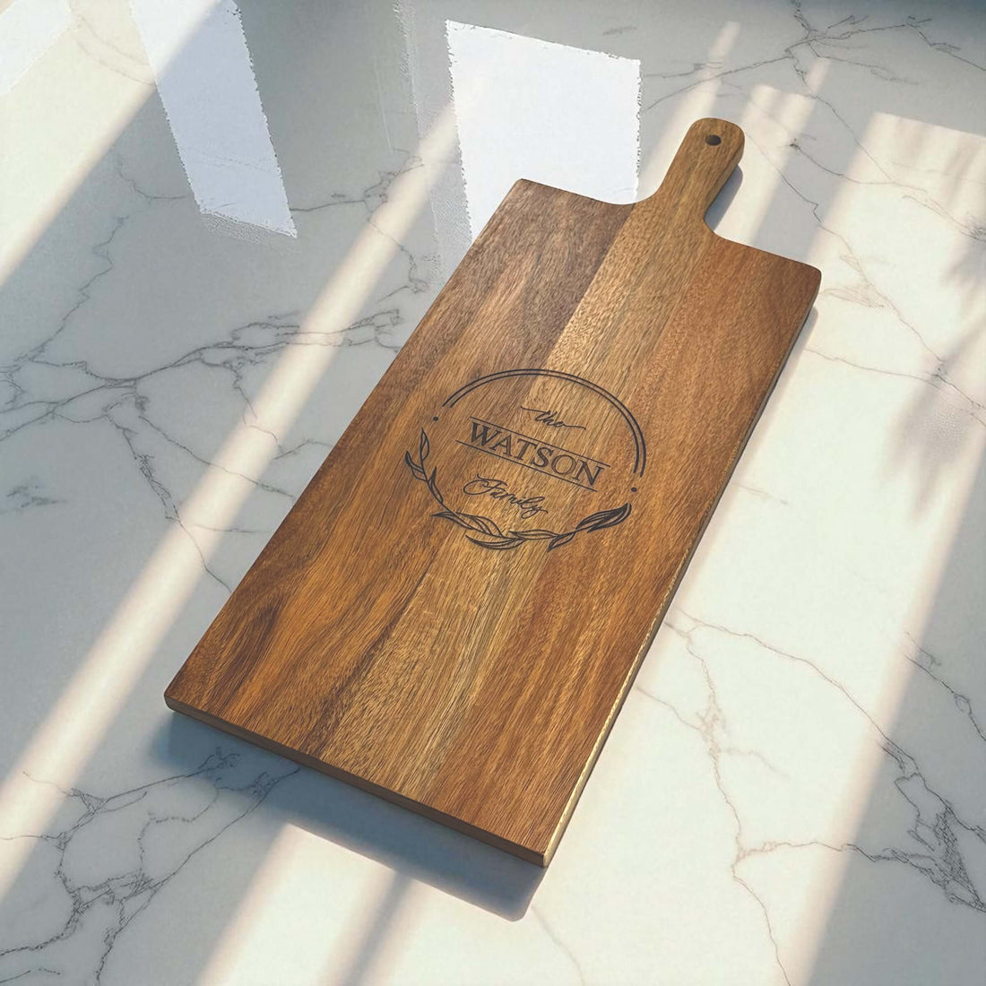 Personalised acacia serving board engraved with a family surname in a wreath design -- housewarming gift idea NZ