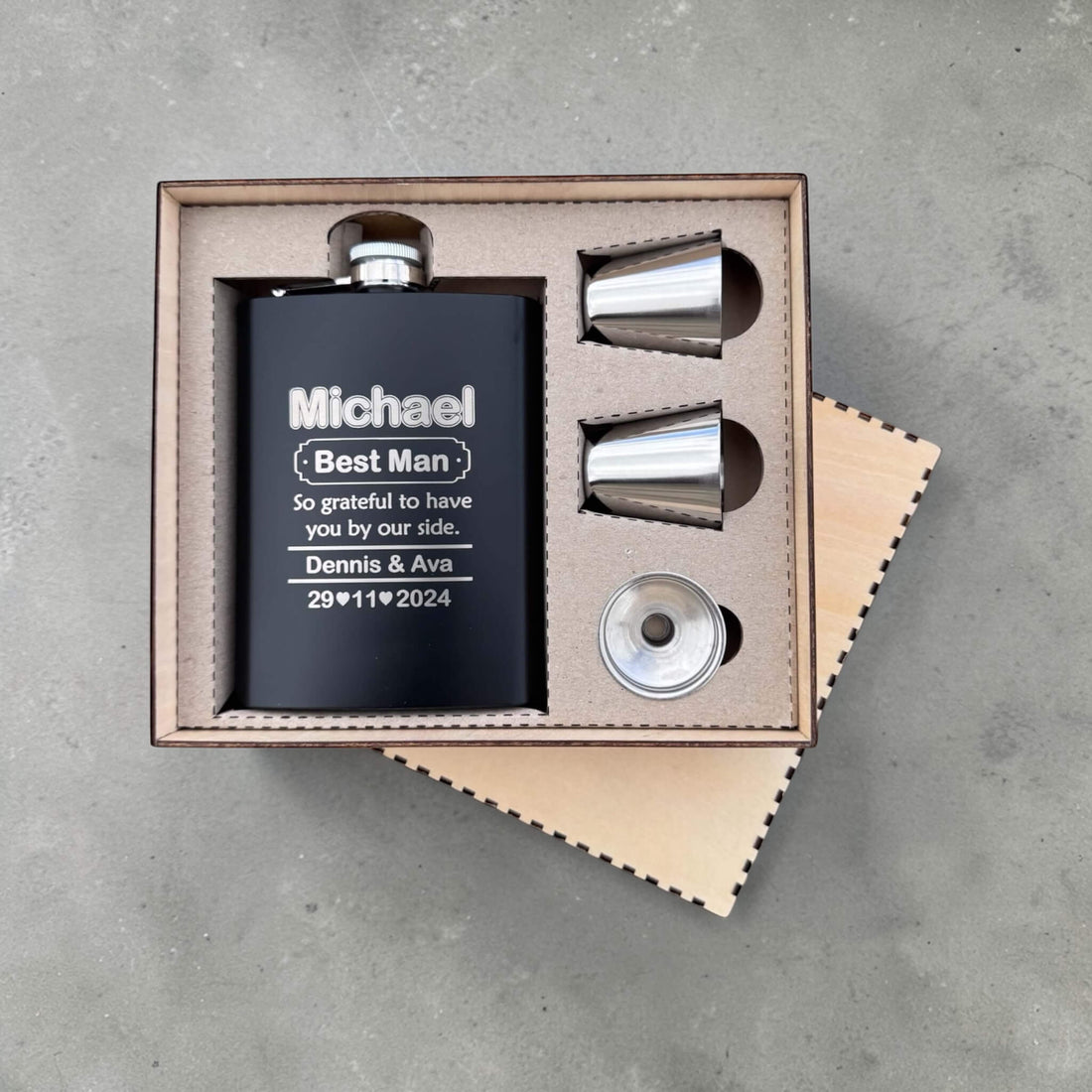 Black engraved groomsmen hip flask set with name, best man role, couple name and wedding date in a wooden gift box