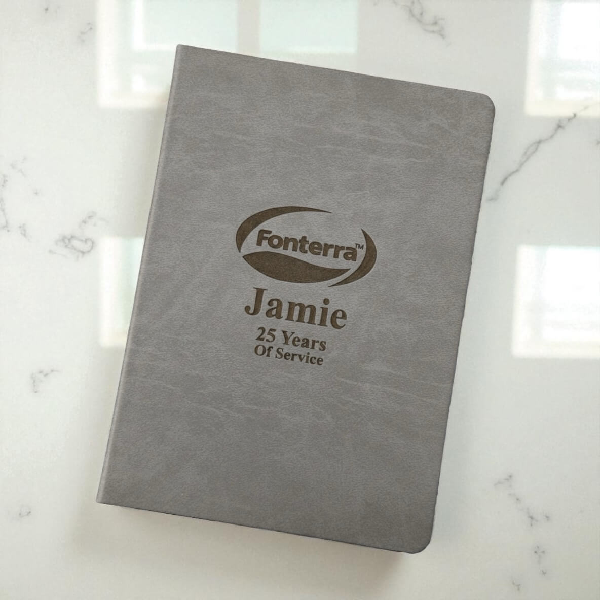 Angled view of professional grey A4 journal with engraved branding and personalisation, great for business events, client gifts, or employee milestones.