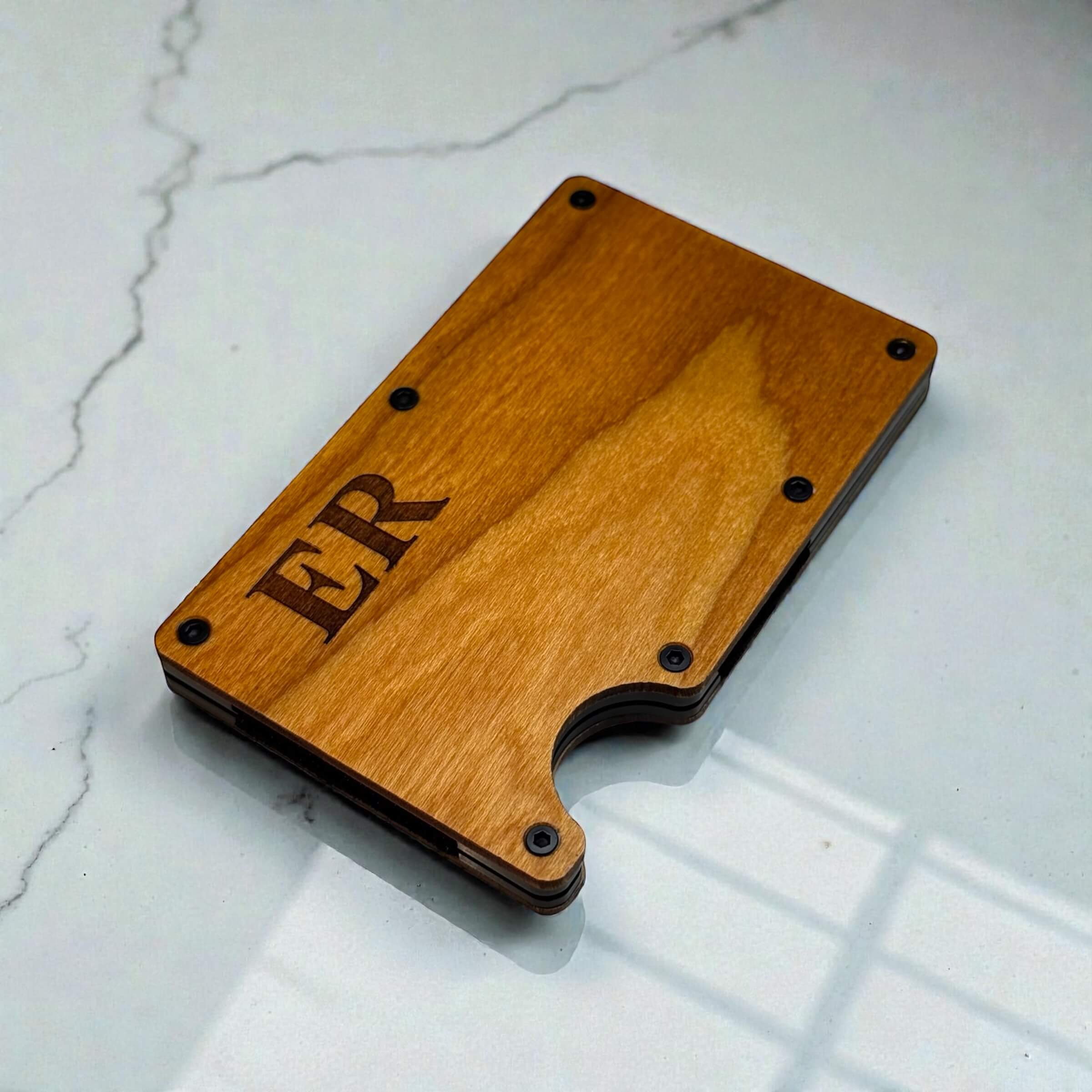 Angled view of slim card holder with timber finish and engraved initials on the front