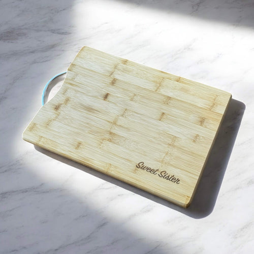 Bamboo board displayed on kitchen counter with natural light, engraved with custom message