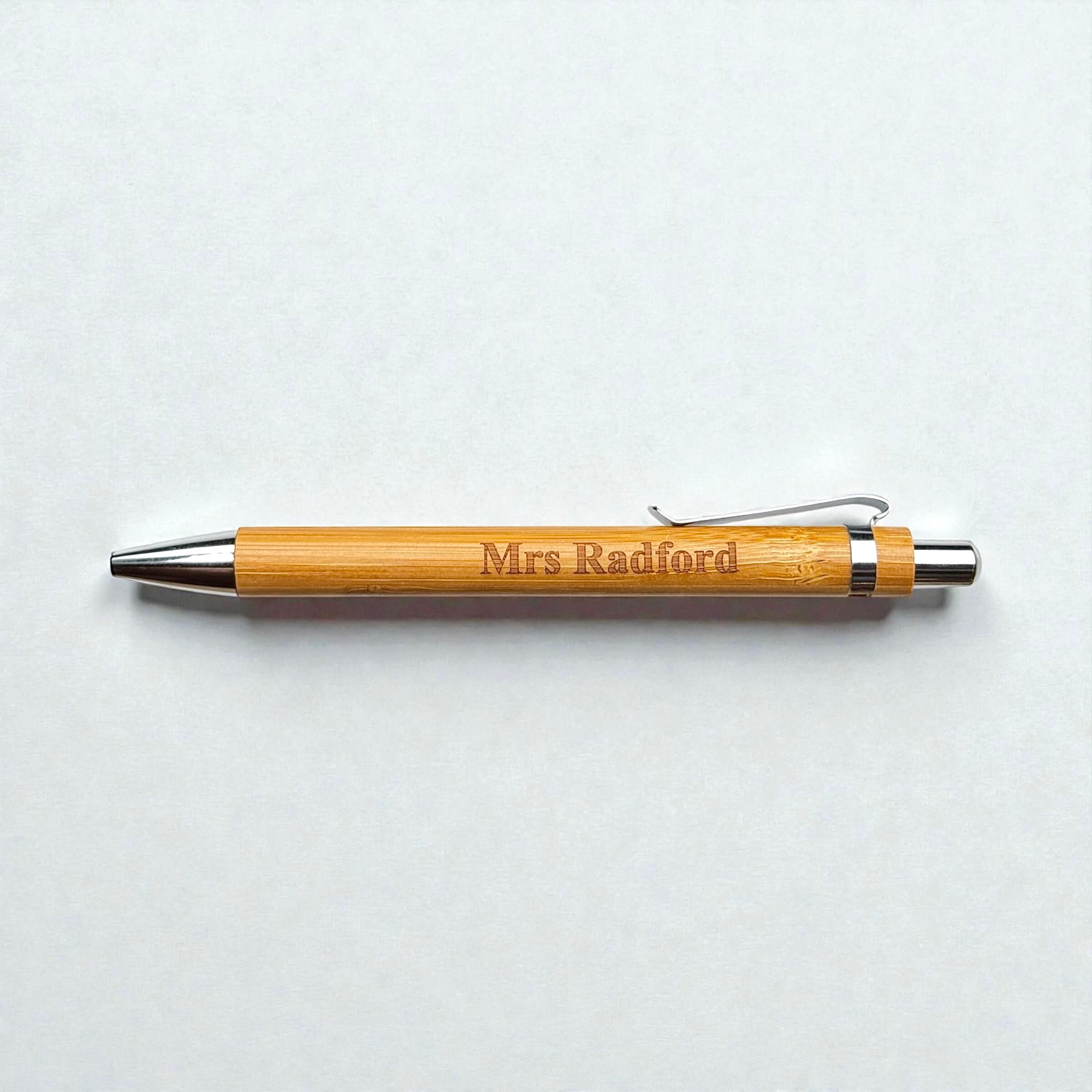 Bamboo pen with 'Mrs Radford' engraving on a light gray background