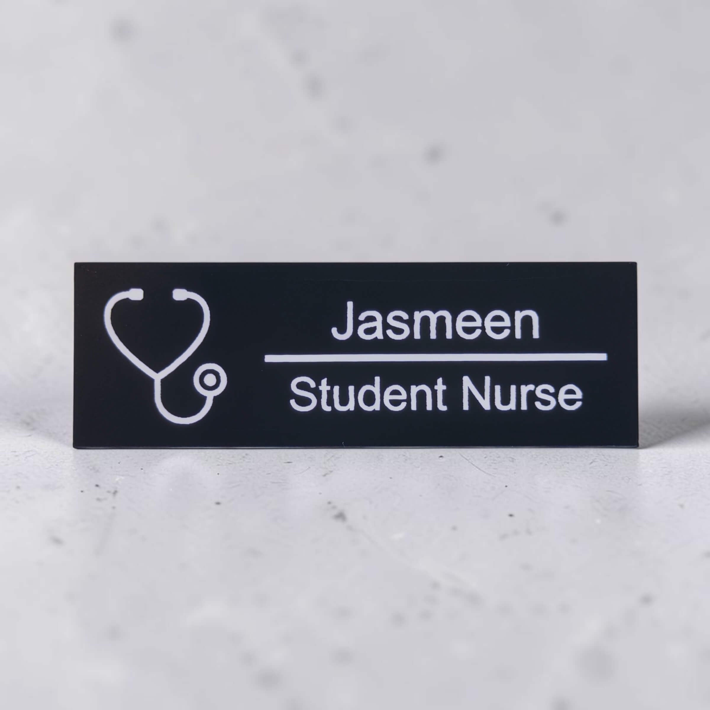 Black acrylic nurse name badge engraved with Jasmeen and Student Nurse