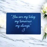 Black aluminium metal wallet card engraved with a personal message on marble background