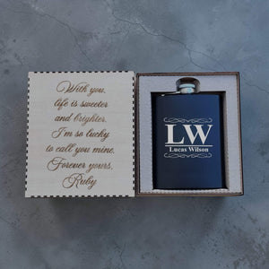 Black flask with 'LW Lucas Wilson' engraving in a box with a sentimental message on a gray background