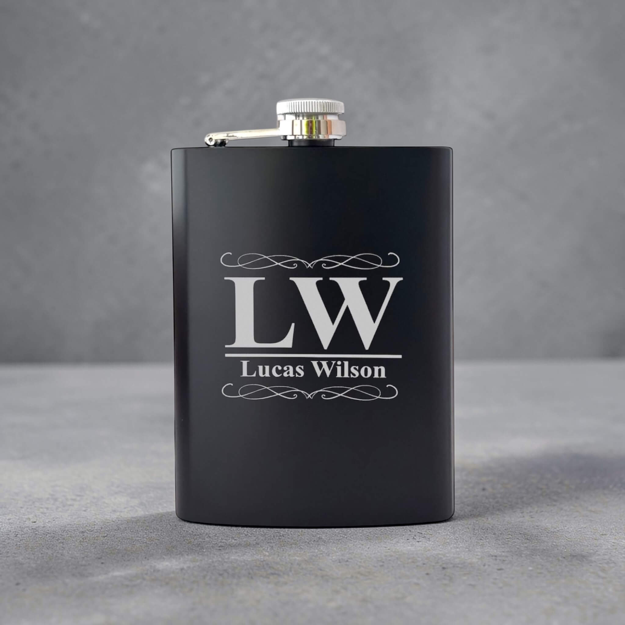 Black flask with 'LW Lucas Wilson' engraving on a gray background