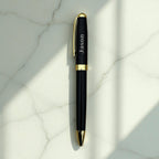 Black metal pen engraved with a name on marble surface