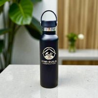Black water bottle with 'Kiwi Build Construction' logo on a table with a blurred background