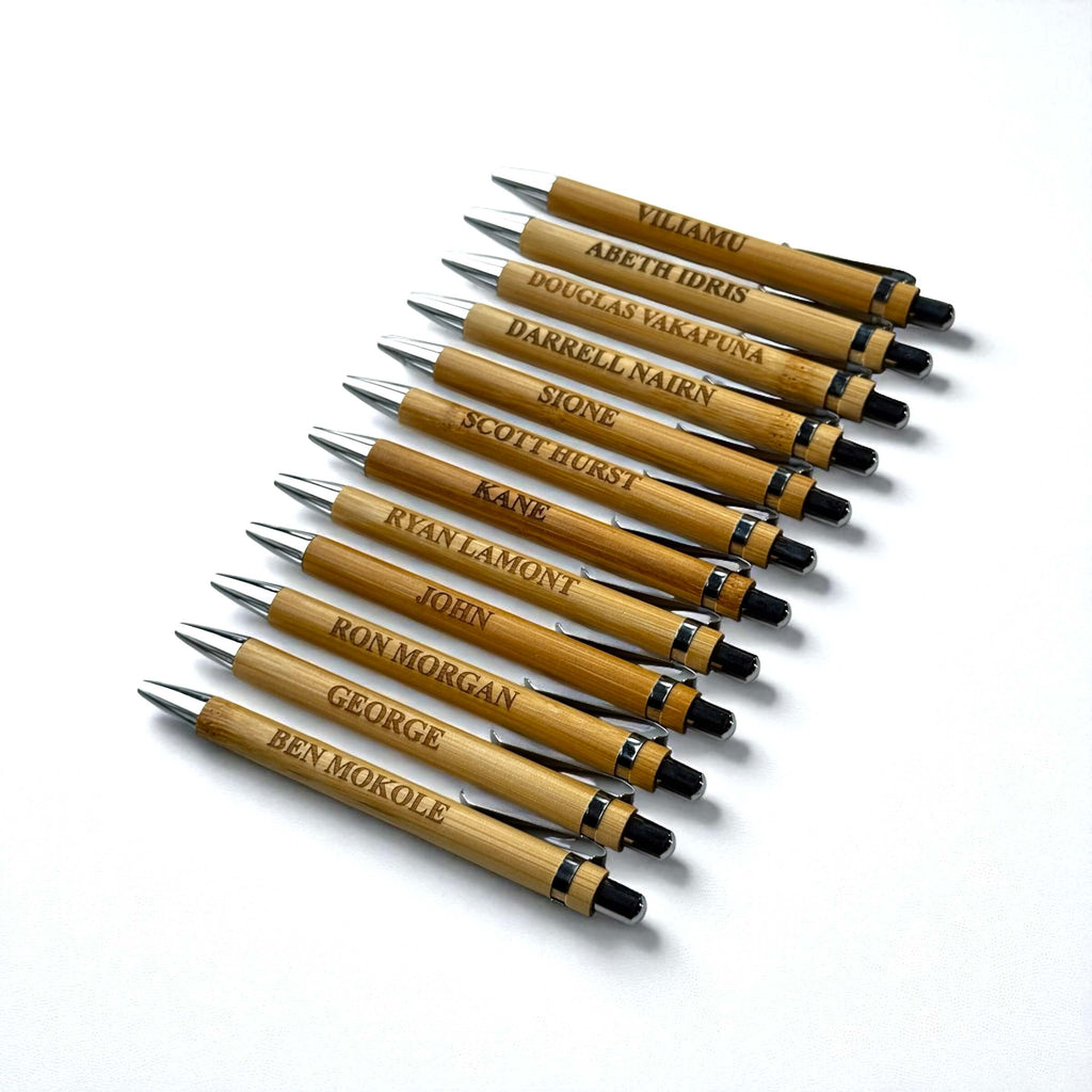 Branded bamboo pens with engraved names, neatly arranged on a white background for business promotions.