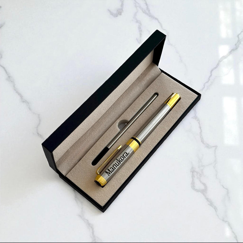Branded engraved pen inside luxury gift box, photographed on marble background.