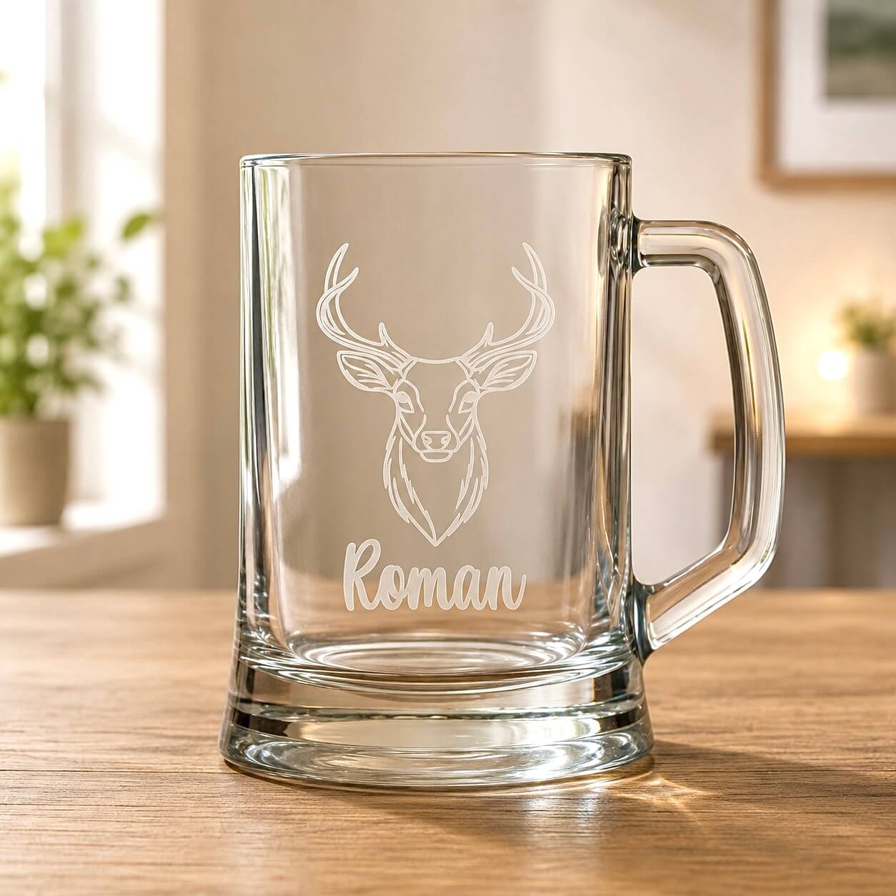 Clear beer mug with engraved stag head and Roman name on wooden table