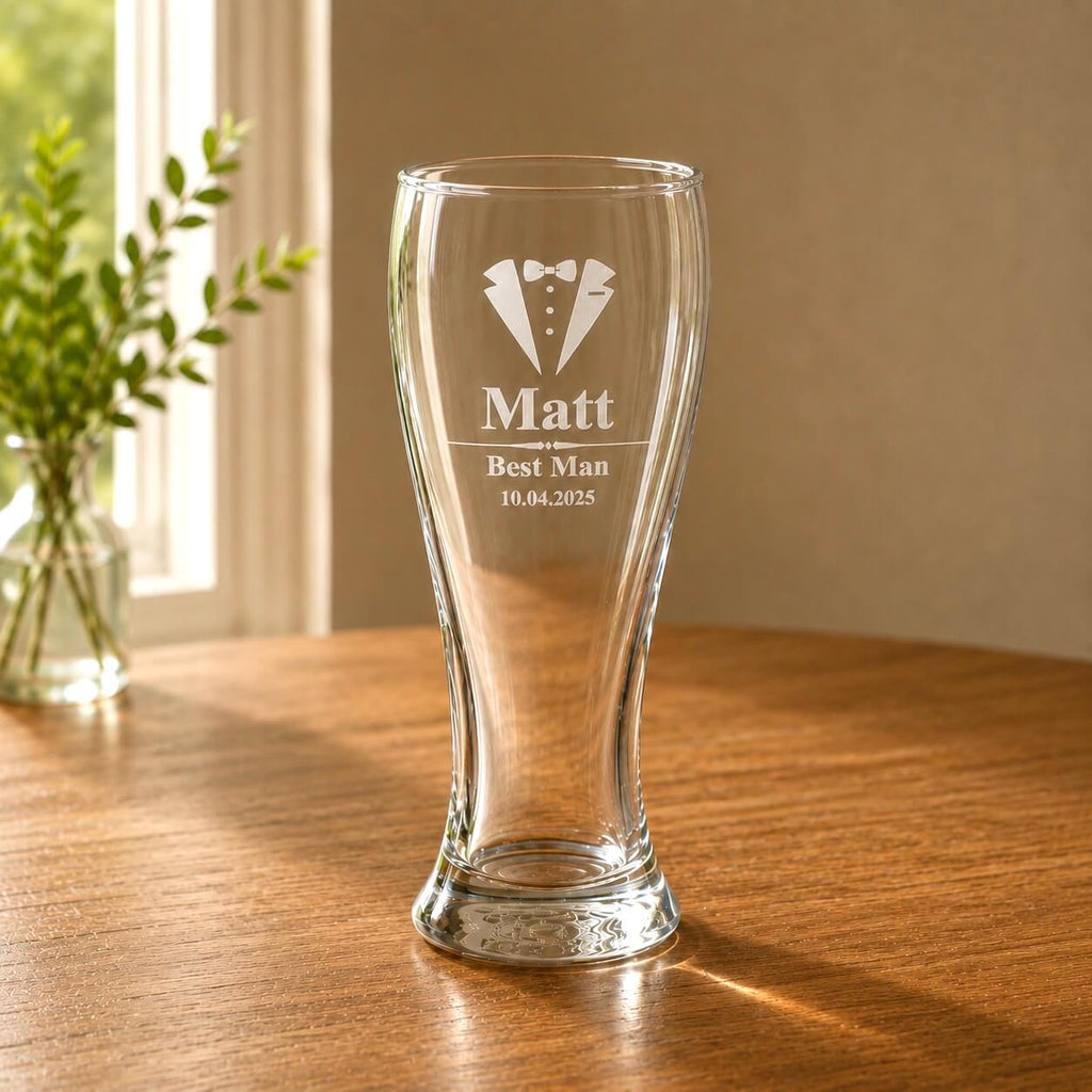 Clear engraved pint glass for a groomsman gift beside a bright window