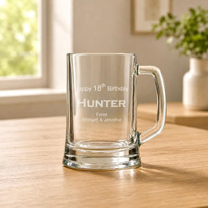 Clear glass beer handle with etched 18th birthday message in warm home setting