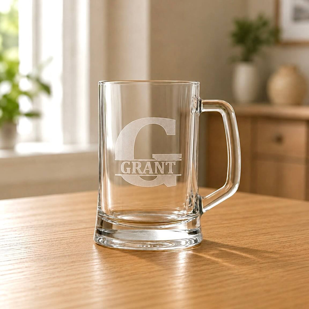 Clear glass beer tankard with etched G initial and Grant name on wooden table