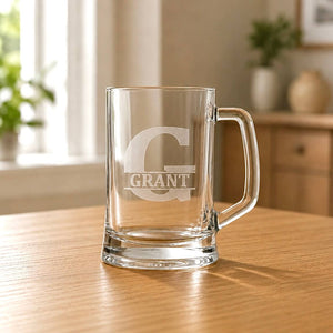 Clear glass beer tankard with etched G initial and Grant name on wooden table