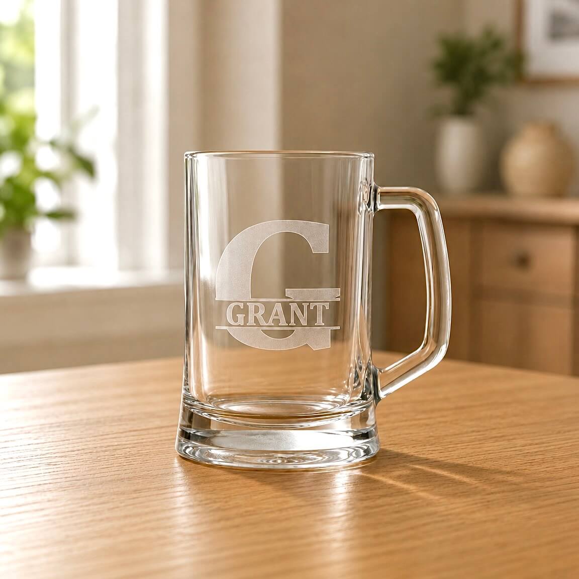 Clear glass beer tankard with etched G initial and Grant name on wooden table