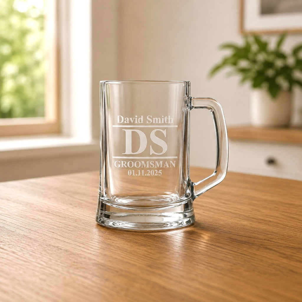 Clear glass beer tankard with etched groomsman design and David Smith name in warm home setting