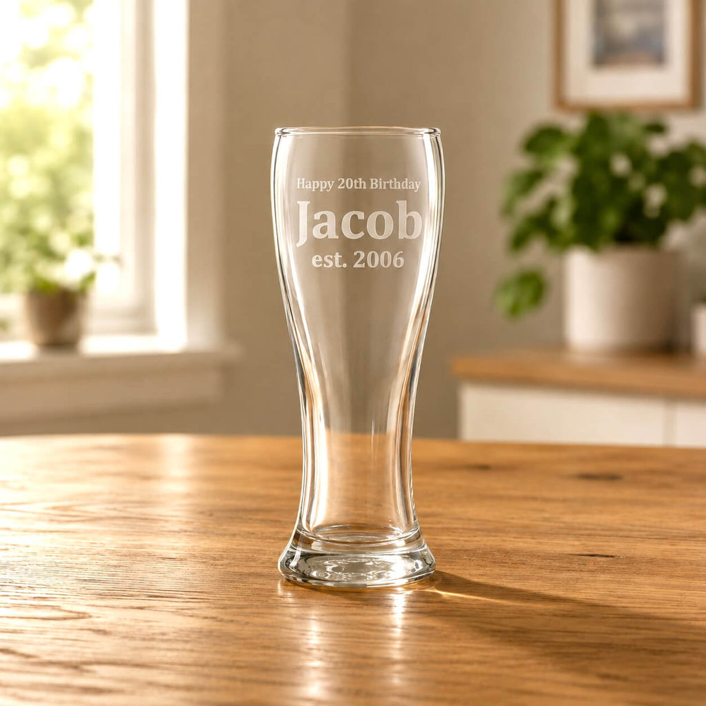 Clear glass engraved with 'Happy 20th Birthday Jacob est. 2006' on a wooden table.