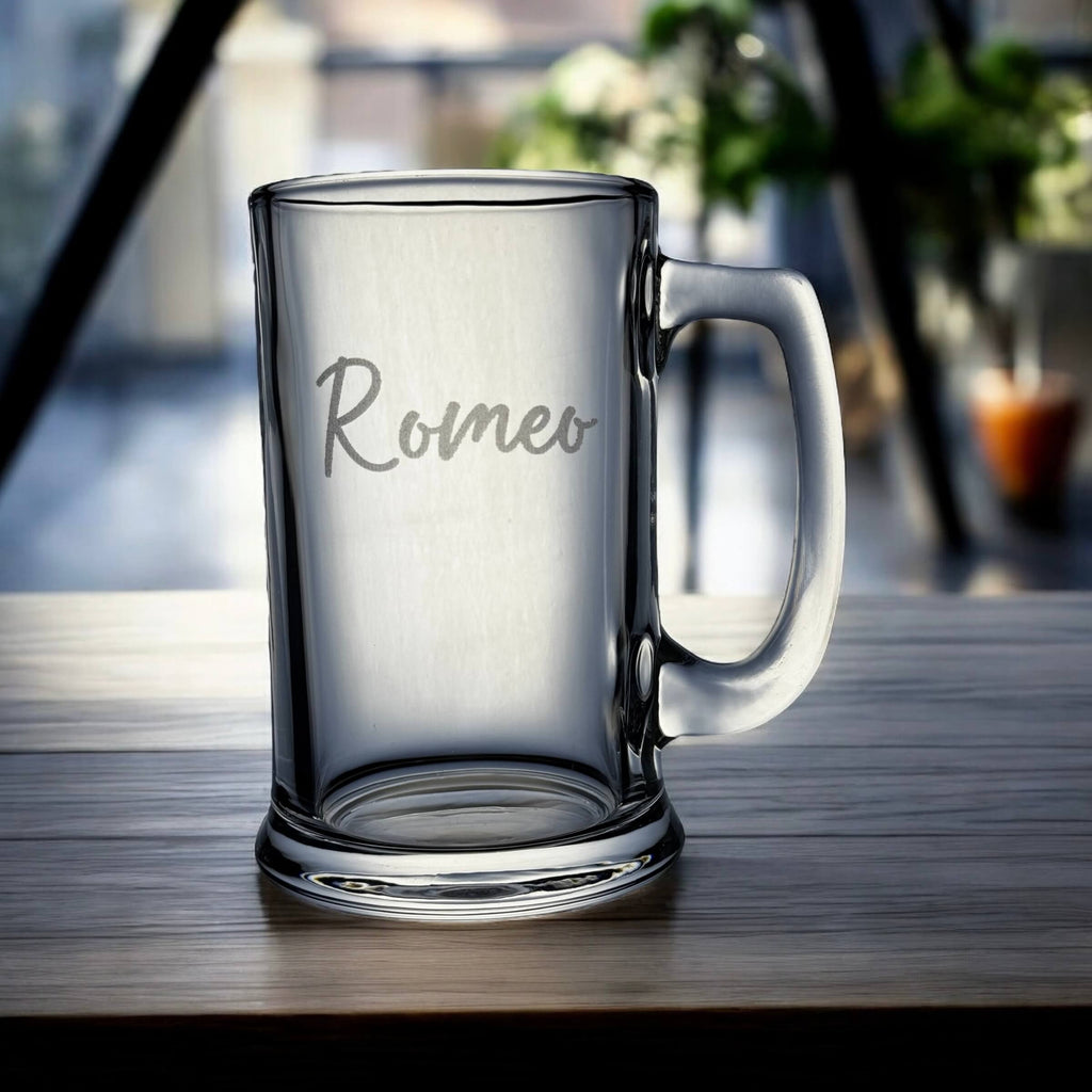 Clear glass mug with 'Romeo' engraving on a wooden surface