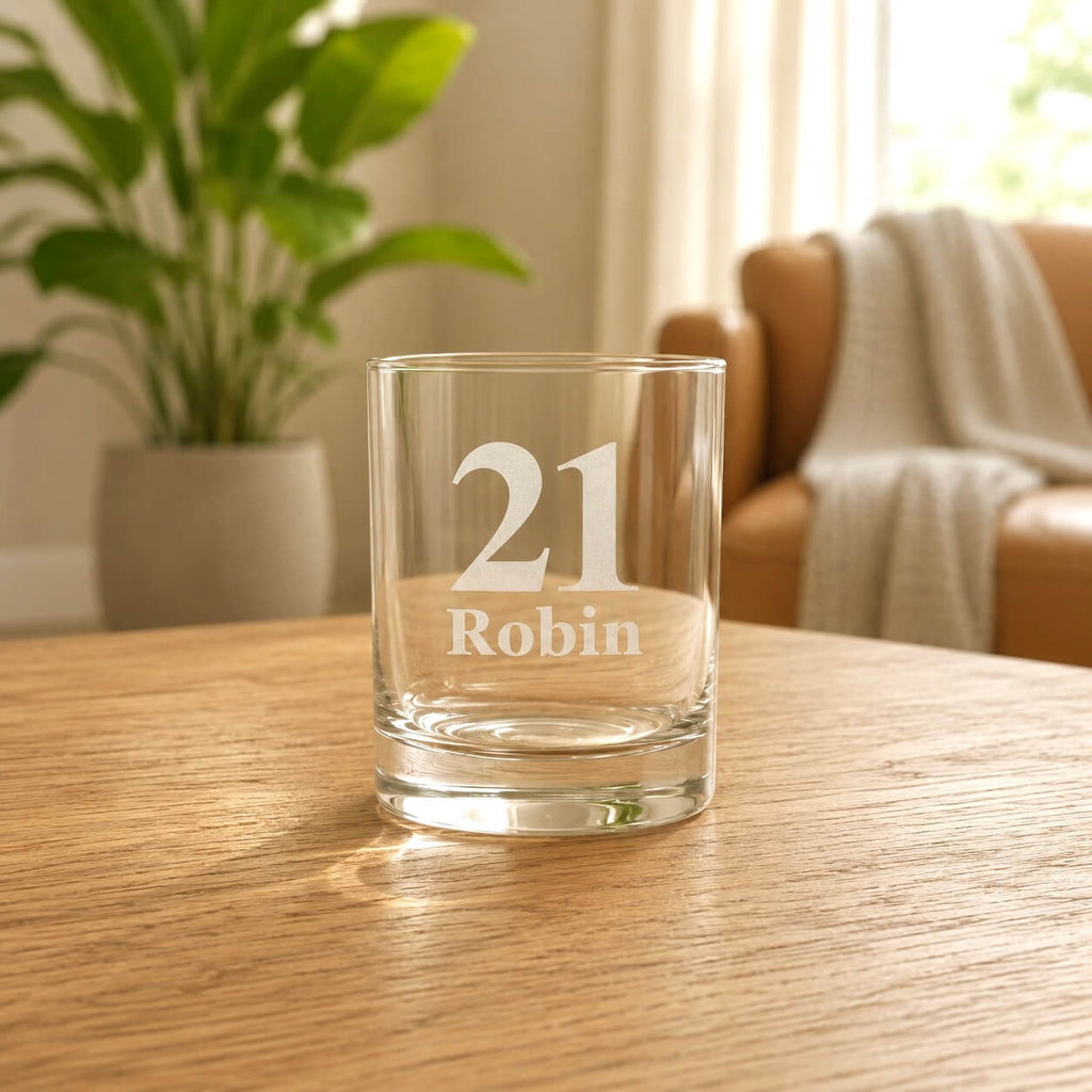 Clear glass shot glass with frosted 21 and name etching on a wooden table