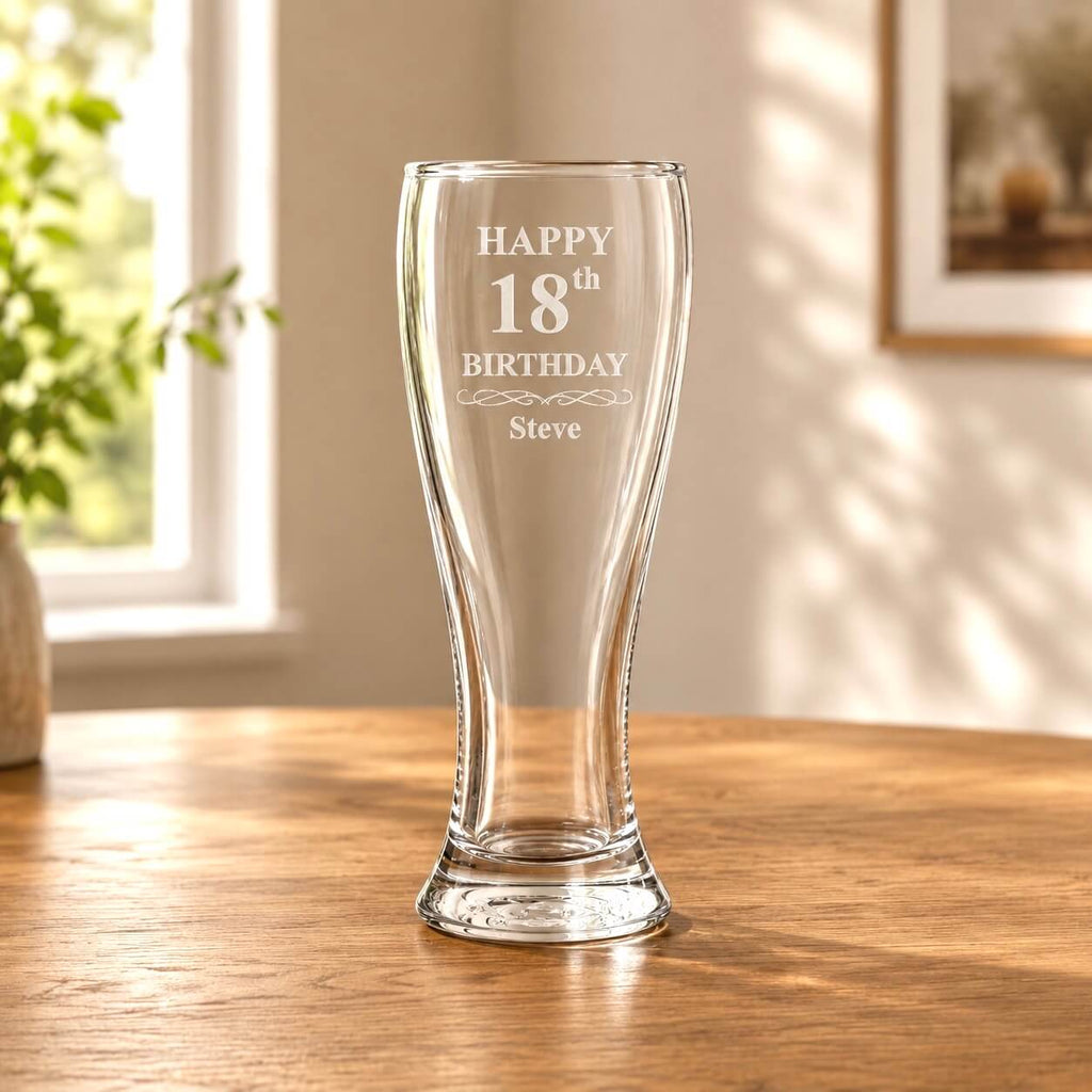 Clear personalised glass with engraved 'Happy 18th Birthday Steve' on a wooden table.