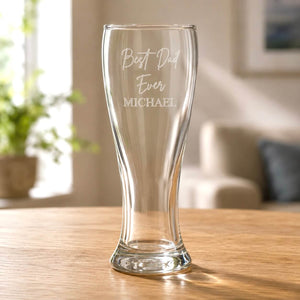 Clear pilsner beer glass with engraved Best Dad Ever Michael message on wooden table