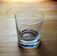 Clear side view of engraved whiskey glass showing "Harry Marshall" etched near the base