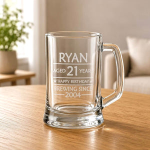 Close-up of clear glass beer mug with engraved 21st birthday message and thick base