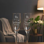 Close-up of custom laser-engraved Mr and Mrs wedding champagne glasses with heart and infinity design.