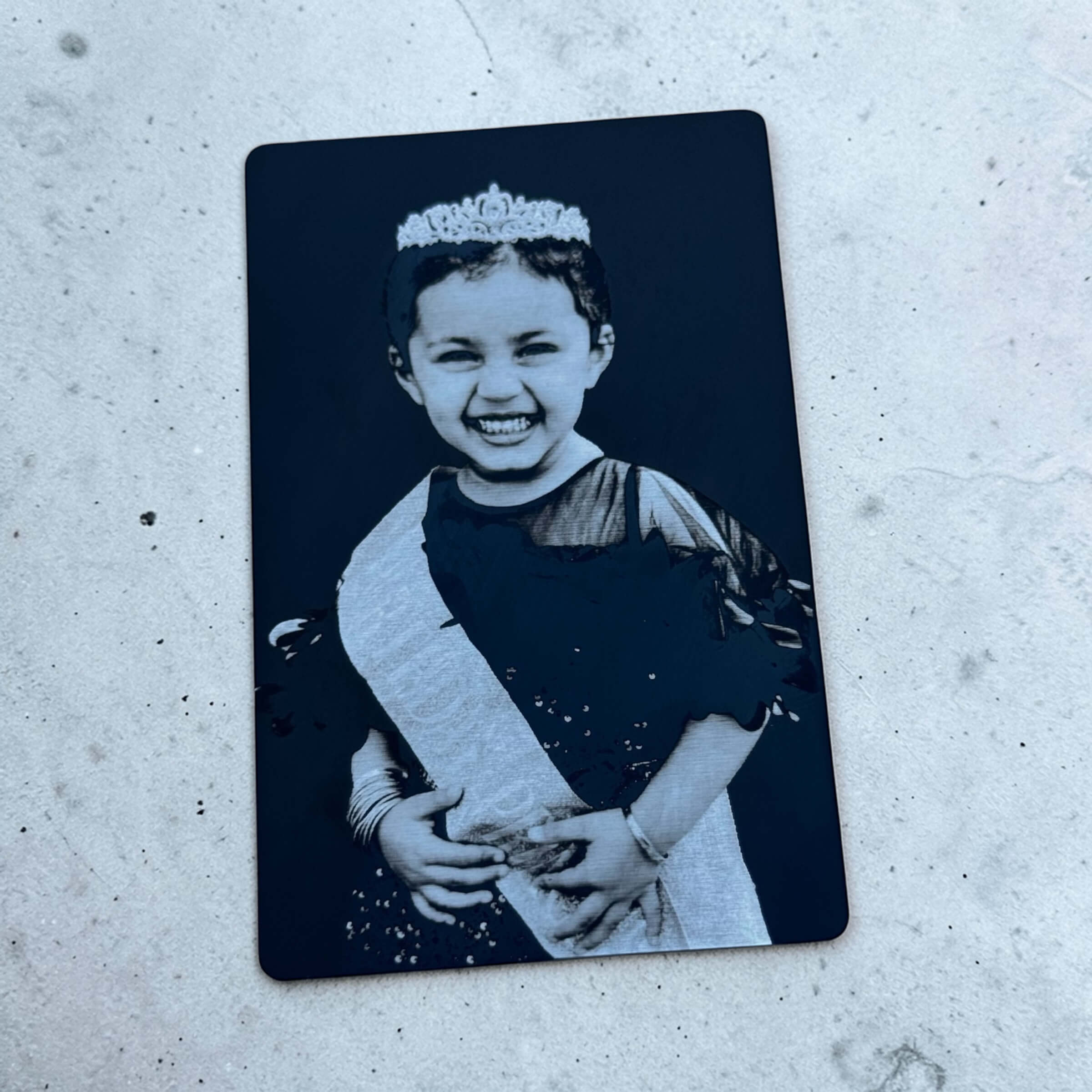 Close-up of custom photo card with laser-engraved image on black metal card