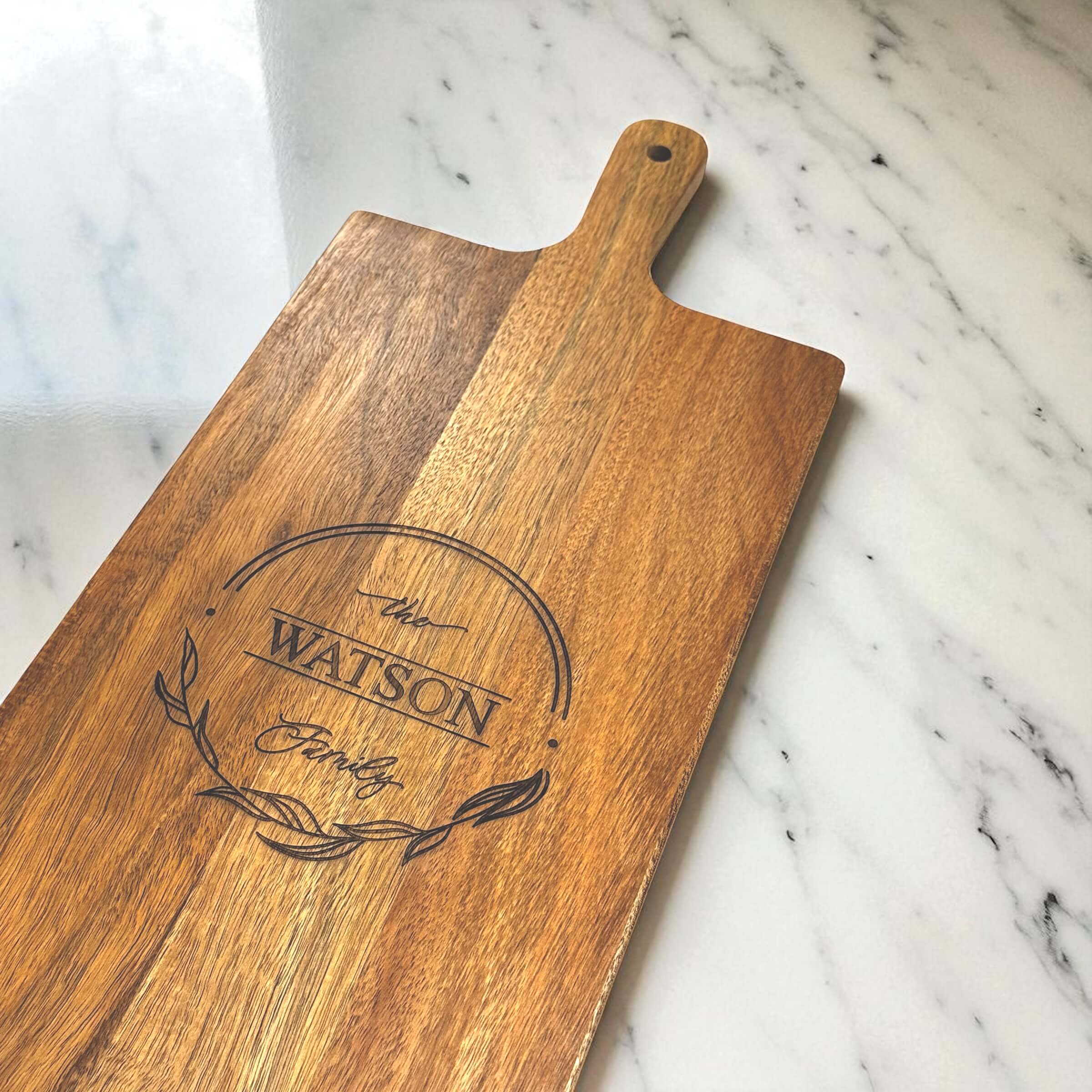 Close-up of custom wooden serving board with The Watson Family engraving