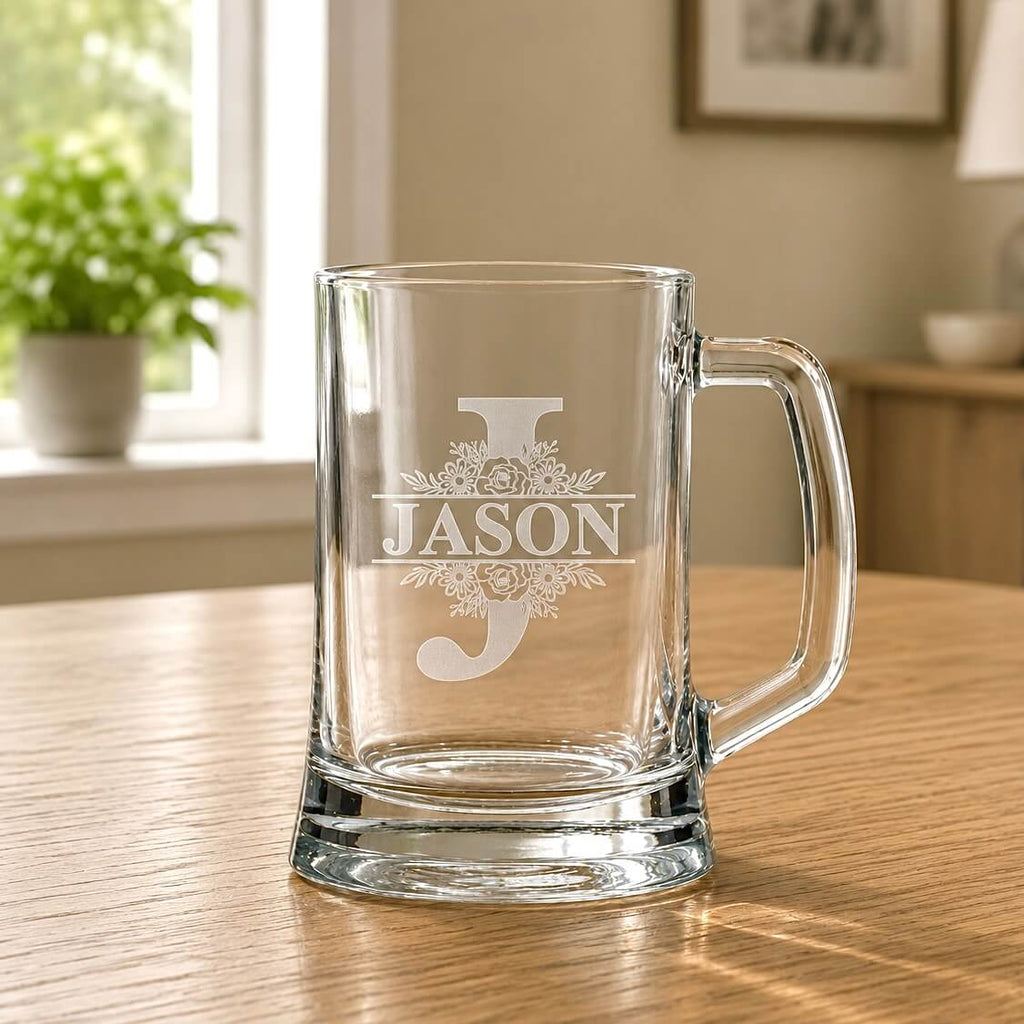 Close-up of engraved beer glass with floral split monogram, Jason name and thick base