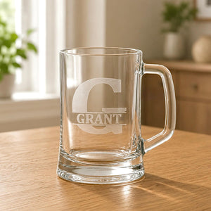 Close-up of engraved beer mug with Grant name, split G initial and warm home background