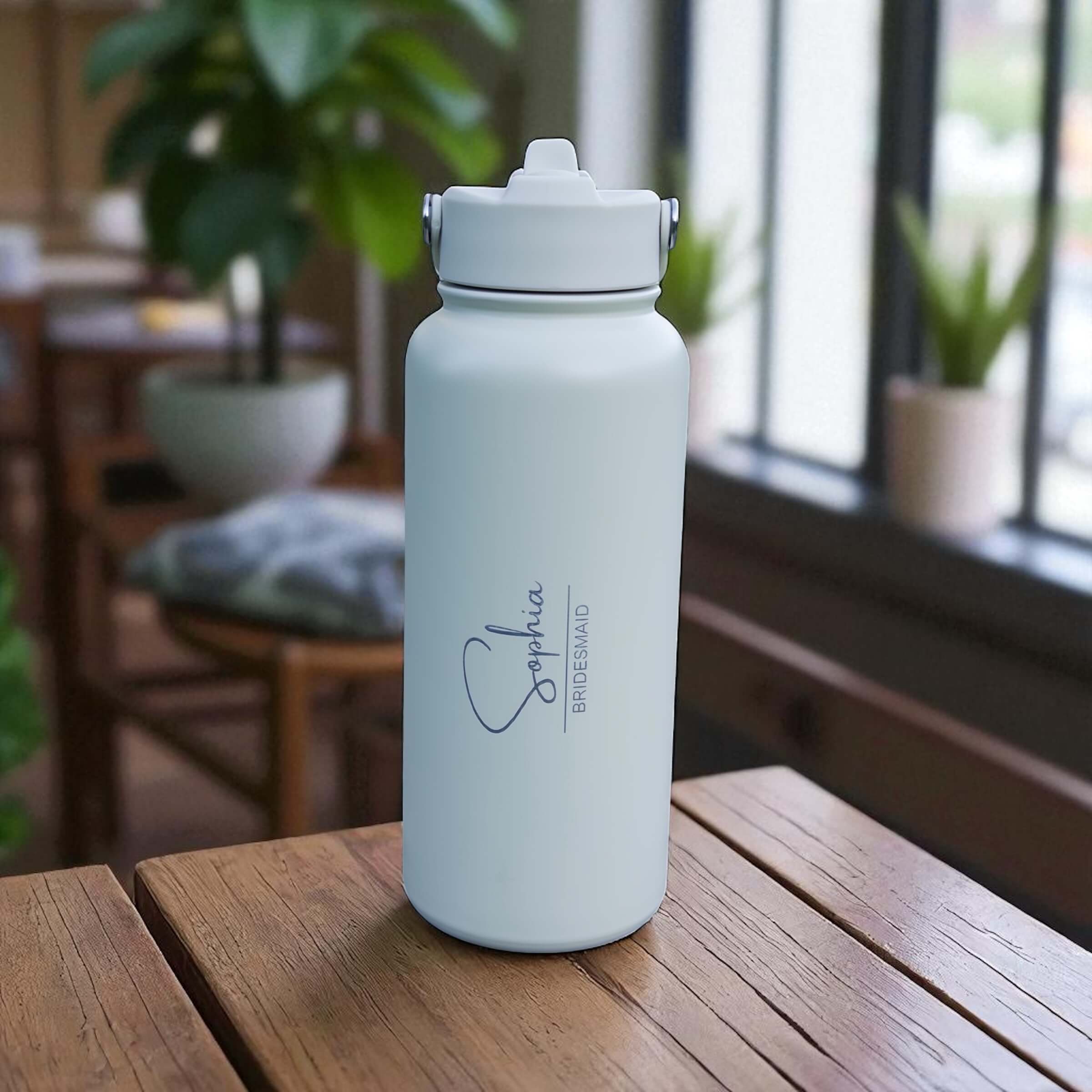 Close-up of engraved bridesmaid name and title on water bottle.