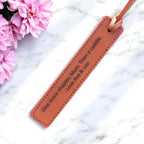 Close-up of engraved message on PU leather bookmark with stitched edges.