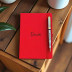 Close-up of engraved silver and gold pen paired with personalised leather notebook