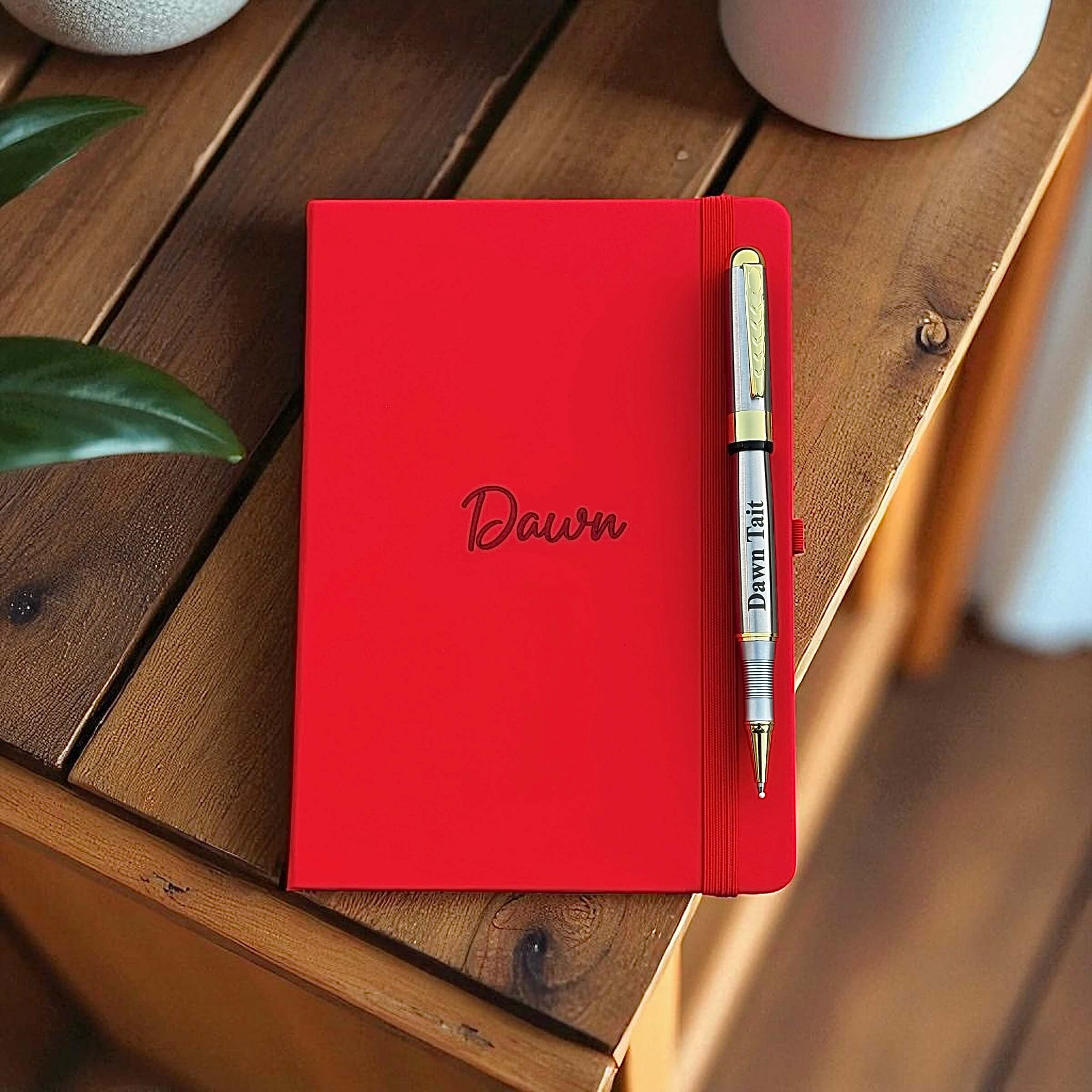 Close-up of engraved silver and gold pen paired with personalised leather notebook