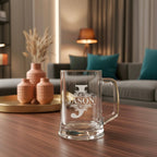 Close-up of laser-engraved J initial and Jason name on clear beer mug showing fine etching detail and elegant floral pattern