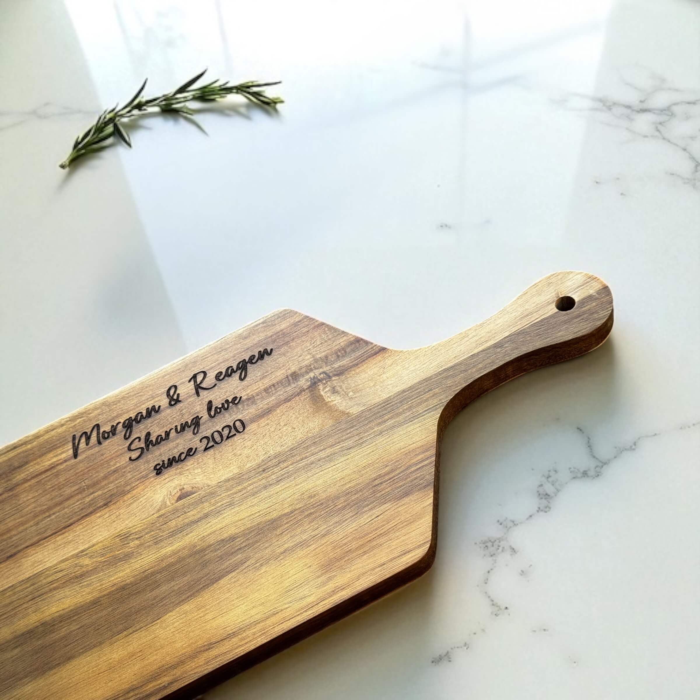 Close-up of laser-engraved handle section on custom wedding gift board with natural wood grain.