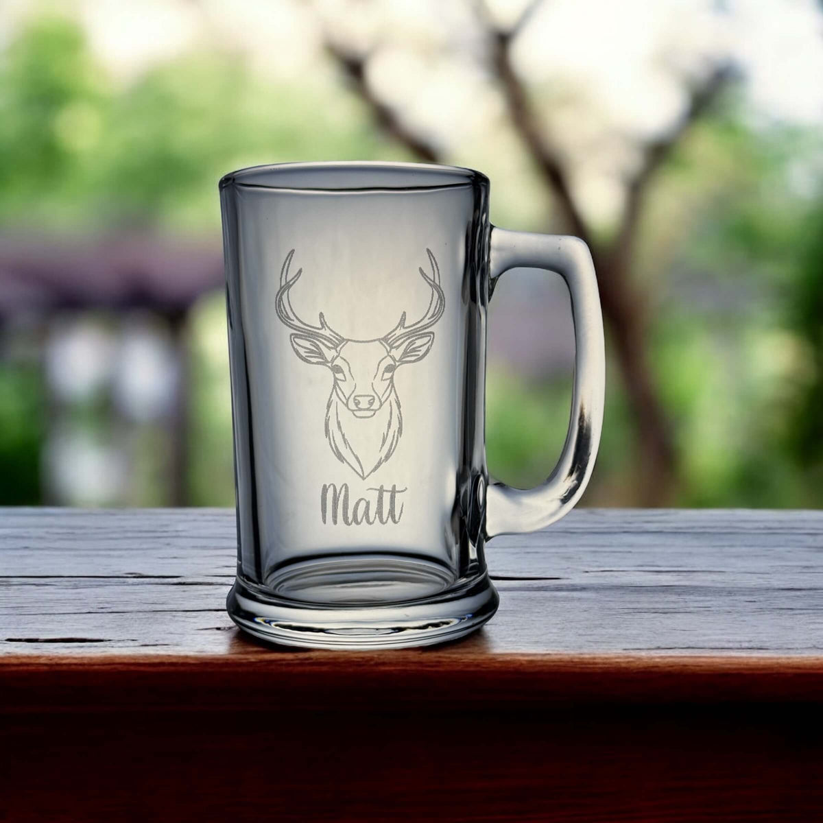 Close-up of laser-etched deer head design with personalised text below on clear glass.