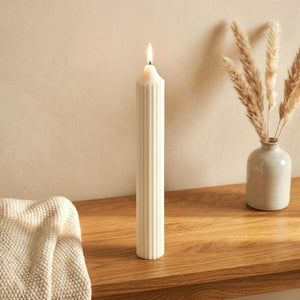 Close-up of the ribbed texture and flame on a hand-poured pillar candle