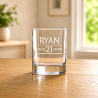 Custom 21st birthday shot glass with frosted Ryan aged 21 engraving on a wooden table