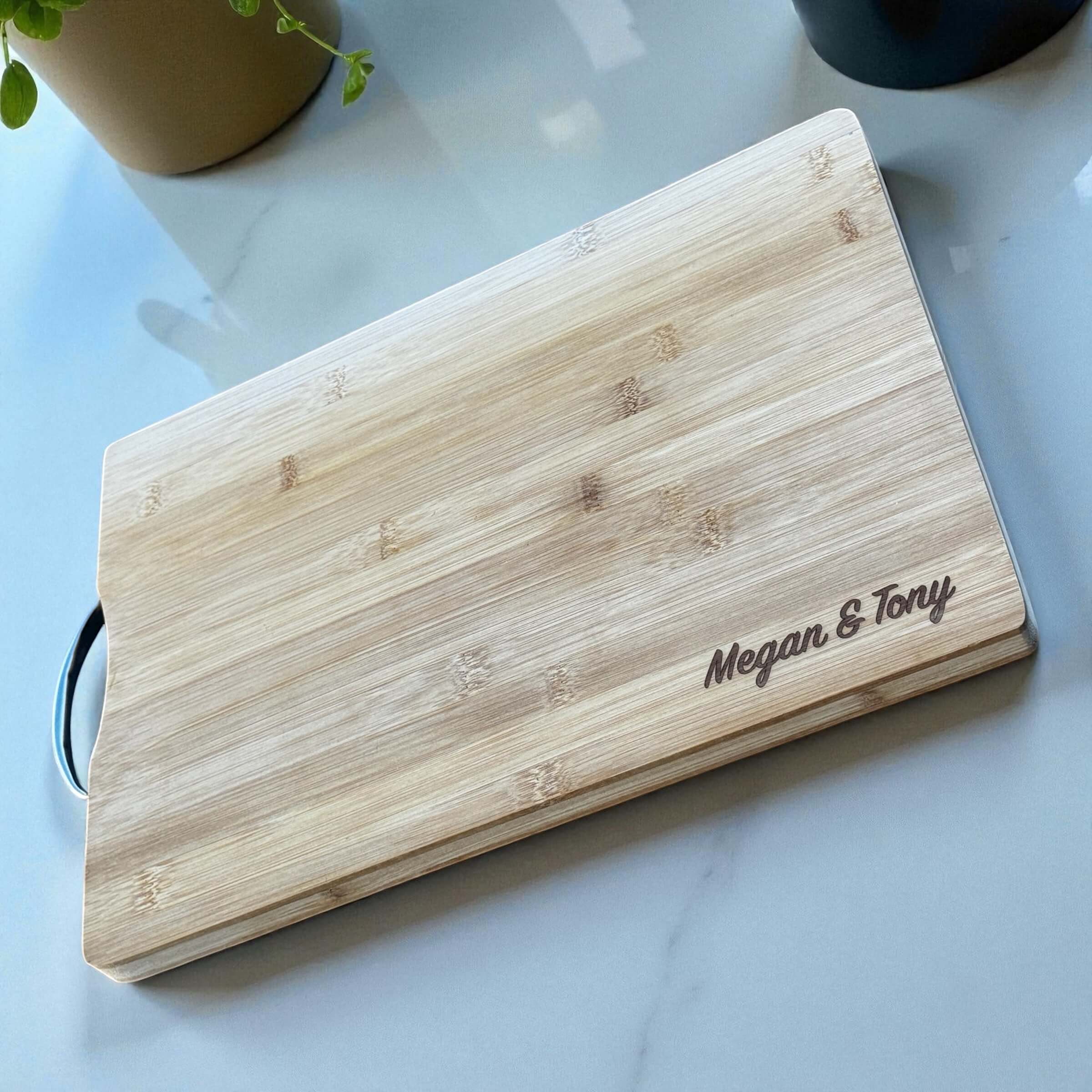 Custom engraved anniversary chopping board styled on a marble surface in a warm kitchen setting