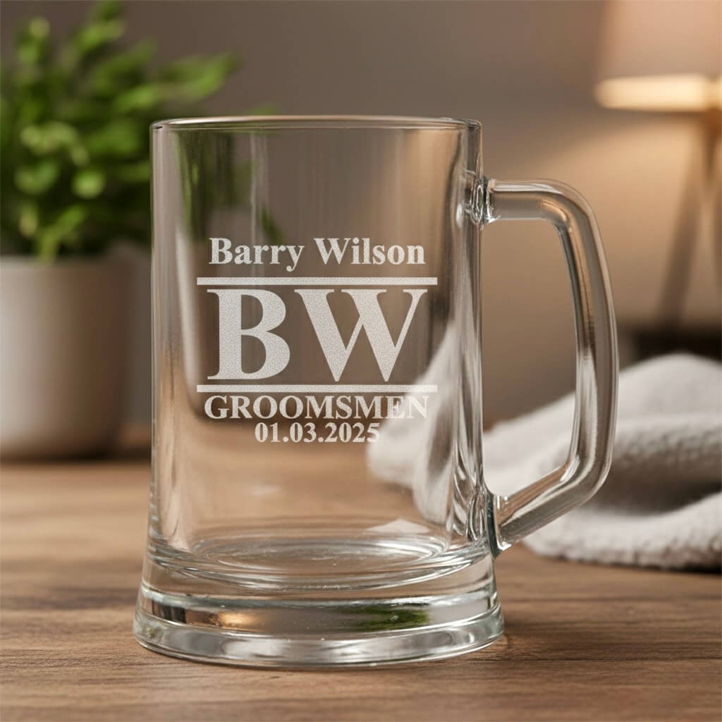 Custom engraved beer glass with BW monogram, Barry Wilson name and groomsmen date design, displayed on wooden table