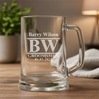 Custom engraved beer glass with BW monogram, Barry Wilson name and groomsmen date design, displayed on wooden table